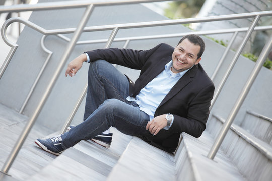 Latino businessman smiling on the steps