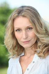 Headshot of serious blonde woman outdoors