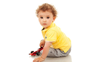 little boy plaing with a toy car