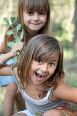 2 fillettes jouant dans la forêt (été, 5-6 ans) - obrazy, fototapety, plakaty