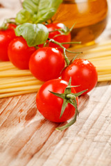 pasta, olive oil and tomatoes on the wood background