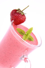 Strawberry shake in a glass decorated with a strawberry and mint