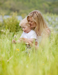 Mother and Son with Dandelion in Meadow