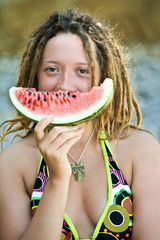 Dreadlock gils hold a piece of watermelon