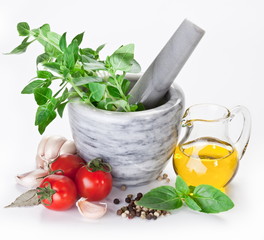 Mortar with pestle and basil herbs and olive oil.