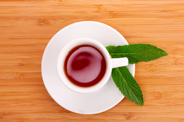 Cup  with mint on wooden background