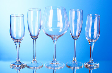 Few empty wine glasses on blue background