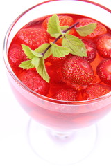 Jelly with strawberries decorated with a mint twig