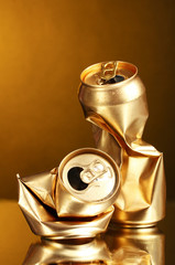 crumpled golden tin can on a yellow background