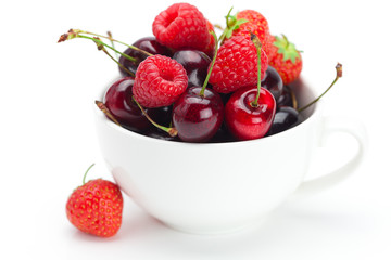 raspberries, strawberries and cherries in a bowl isolated on whi