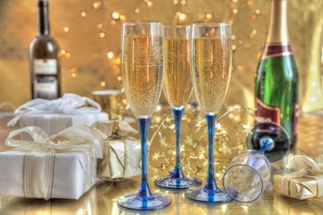Champagne in glasses and gifts on gold background