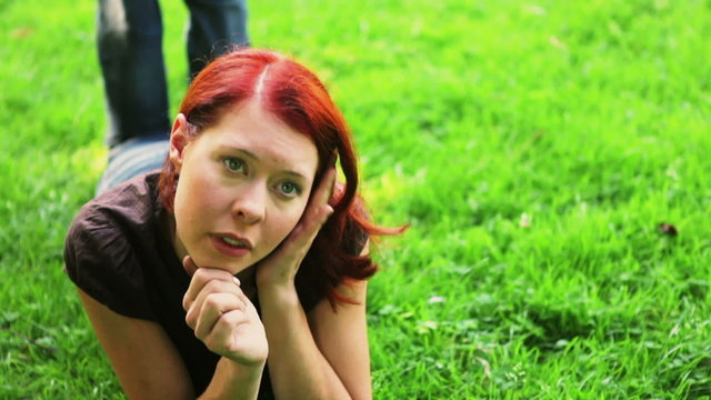 Redhaired woman relaxing on meadow