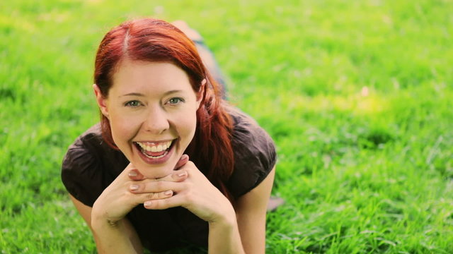 Redhaired girl having fun on grass