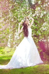 Obraz na płótnie Canvas Beautiful bride in a blossoming garden