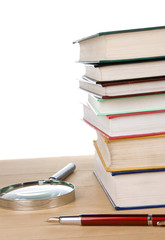 pile of book and pen at table