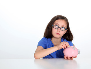Obraz na płótnie Canvas Little girl putting coin in piggybank