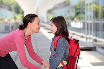 Mother giving kiss goodbye to children