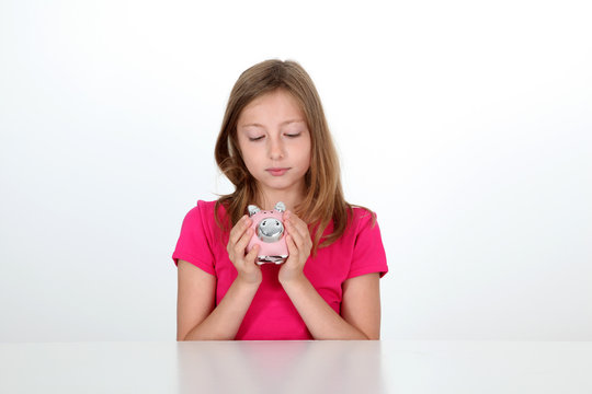 Portrait of young girl holding piggy bank