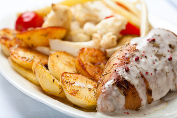 Roasted chicken breast with roasted potatoes and herb sauce