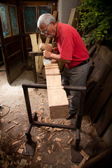 woodcarver working with mallet and chisel