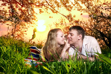 Couple on green grass at sunset