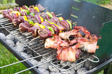 Shashlik with poultry hearts and bacon on grill