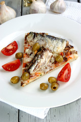 Pizza mit Champignon und Sardine auf einem weißen Teller