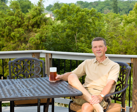 Senior Man Drinking Beer In Garden