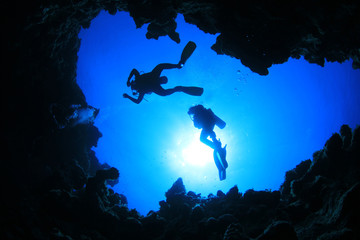 Scuba Divers descend into an underwater canyon