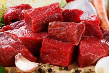 Raw beef on cutting board and vegetables