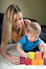 Young mother playing with baby boy