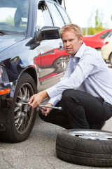 Fototapeta na wymiar Business Man Replacing Tire