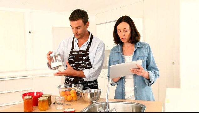 Couple cooking fruit jam at home
