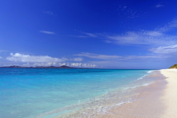真っ白い砂浜に打ち寄せる透明な波と紺碧の空