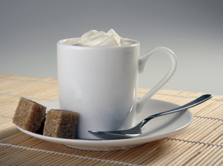 Cup of coffee with whipping cream and sugar