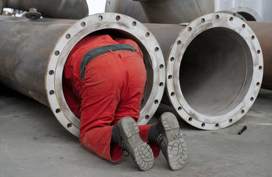 Arbeiter &uuml;berpr&uuml;ft ein Stahlrohr