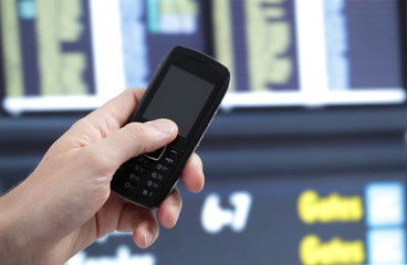 Hand with phone against timetable