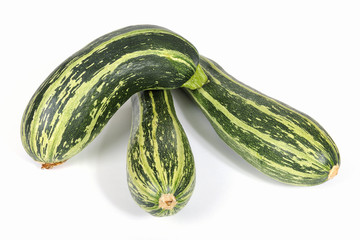 Zucchinis or courgettes on a white surface