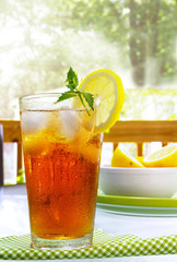 tall glass of cold iced tea with lemon and mint