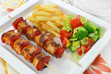 Chicken skewers and french fries