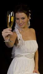 Braut prostet mit Sektglas