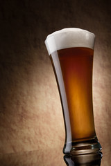 Beer into glass on a old stone