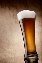 Beer into glass on a old stone