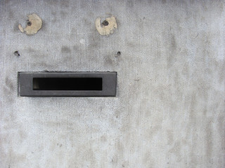 stone wall with mail-box looking like face