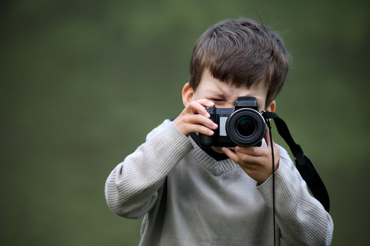 Cute little caucasian boy taking photos