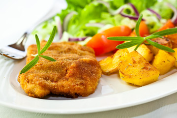 Scnitzel with roasted potatoes,salad and herbs