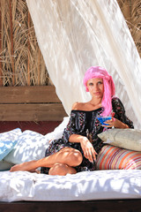 Fototapeta premium Young woman relaxing at lounge beach bar