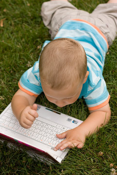 Child with notebook on the grass