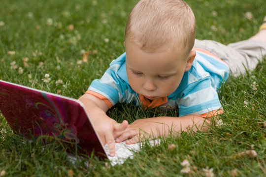 Child with notebook on the grass