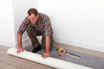 Man unrolling carpet